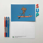 Front and back designs of paddle boarding dog birthday postcard